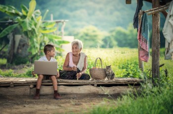Anciana y niño con un gato en su hogar, Myanmar