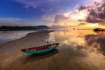 Embarcación sobre la arena al atardecer