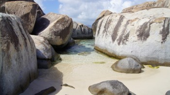 Rocas grandes en arena blanca y mar transparente