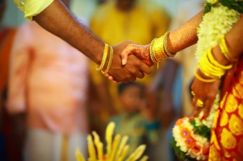 Un hombre y una mujer se dan la mano durante un casamiento indio