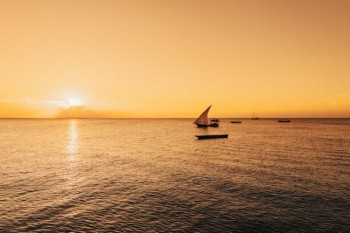 Sailing boat through a beautiful sunrise on the coast of Tanzania how to travel tanzania