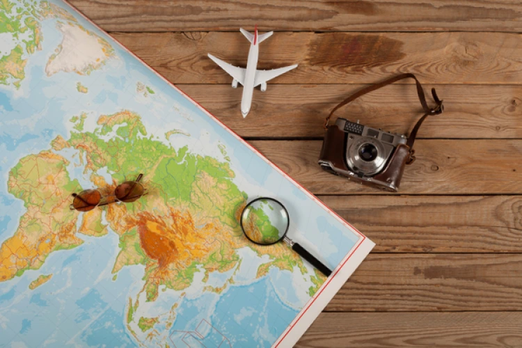 Mappa con un aereo, una fotocamera e una lente d’ingrandimento.