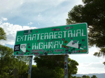 Cartello della Extraterrestrial Highway in Nevada con adesivi dei viaggiatori nei pressi dell'Area 51.