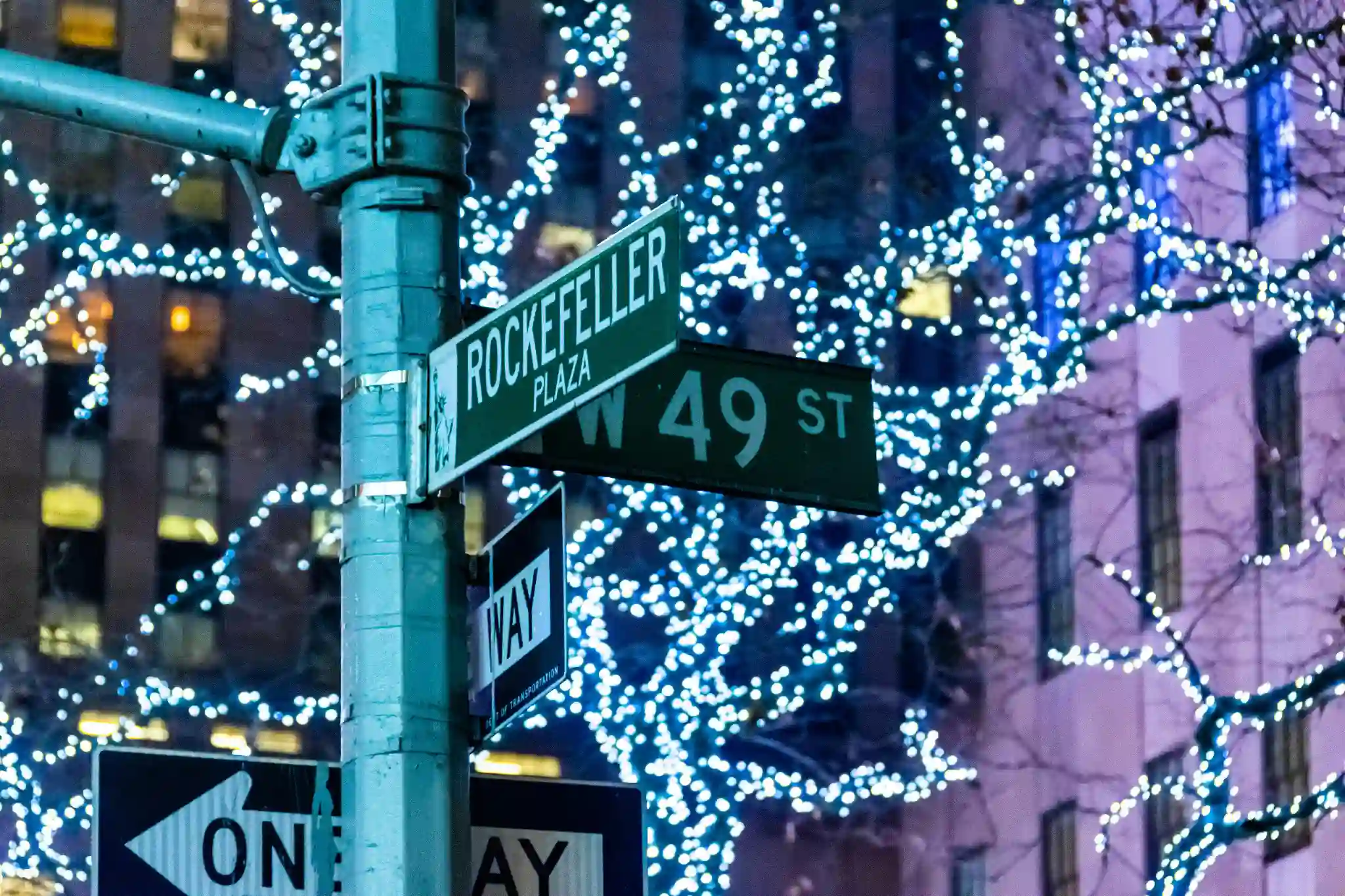 Rockefeller Plaza sign with Christmas lights in New York City.