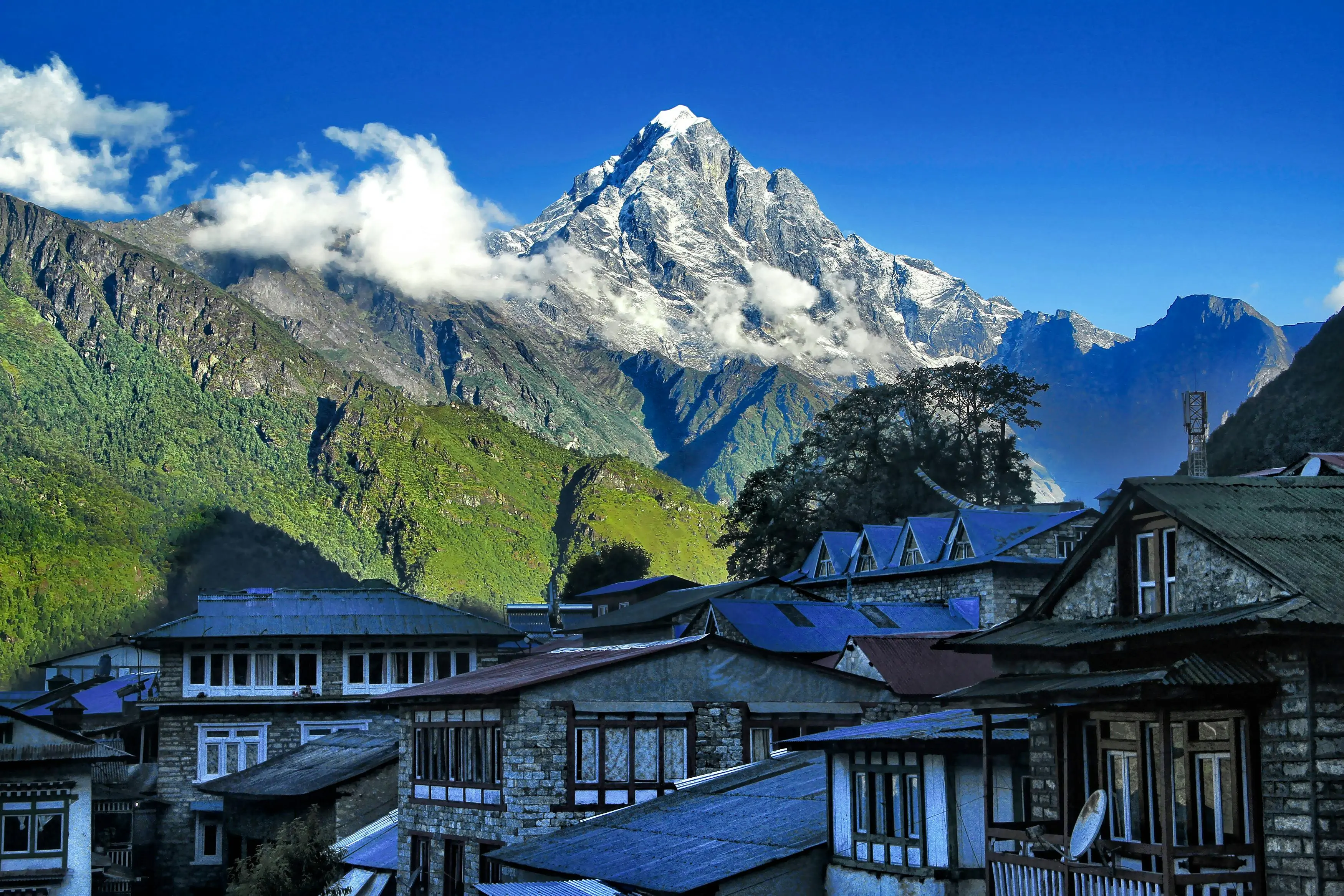 Traditional stone village in Nepal with a snow-capped Himalayan peak rising in the background