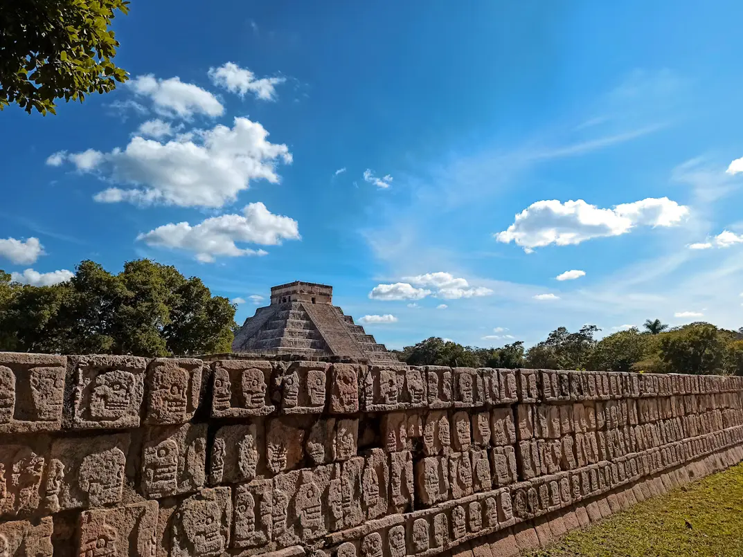 Tzompantli and Kukulcán Pyramid in the background at the archaeological site of Chichén Itzá, Yucatán
